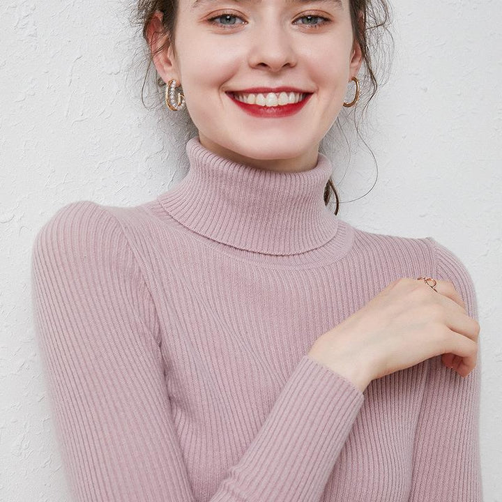 Smiling woman wearing a light purple ribbed turtleneck sweater and gold hoop earrings
