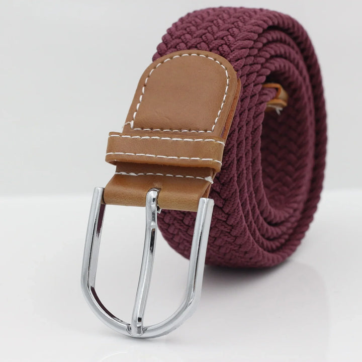 Close-up of woven burgundy fabric belt with tan leather buckle and silver metal clasp