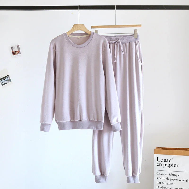 Light purple fleece loungewear set with sweatshirt and jogger pants hanging on wooden hangers