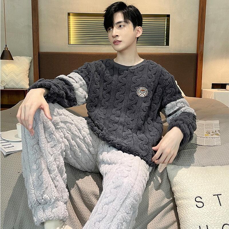 Young man lounging on bed wearing cozy textured knit-patterned two-tone fleece loungewear in dark gray and light gray.