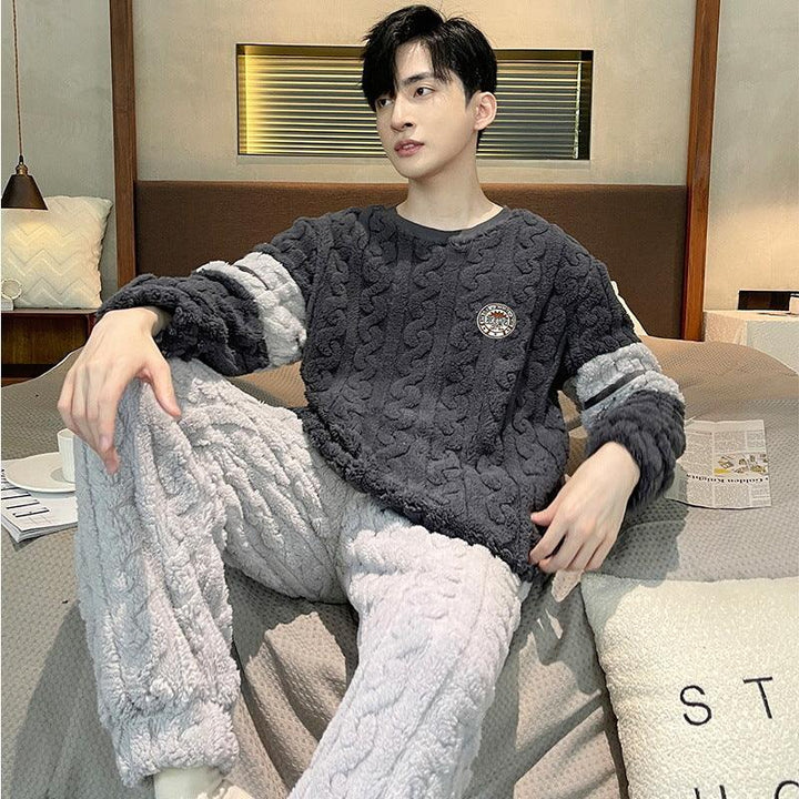 Young man lounging on bed wearing cozy textured knit-patterned two-tone fleece loungewear in dark gray and light gray.
