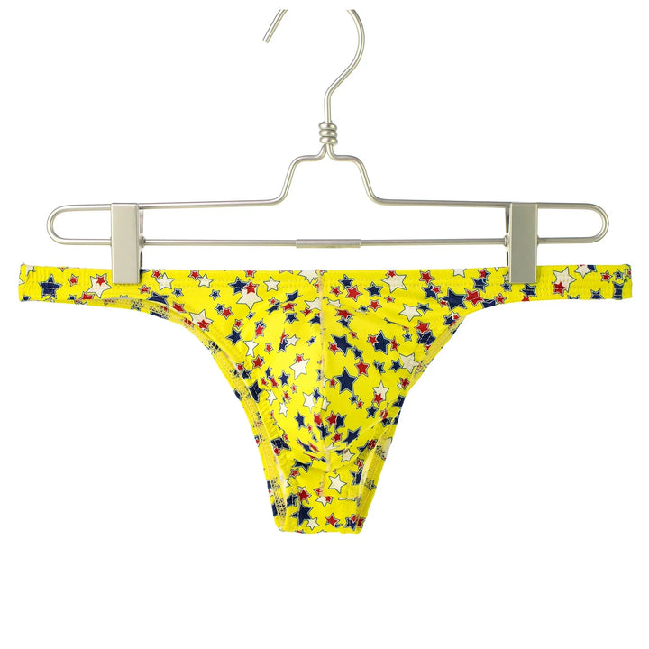 Yellow men's bikini underwear with red, white, and blue star pattern on silver hanger