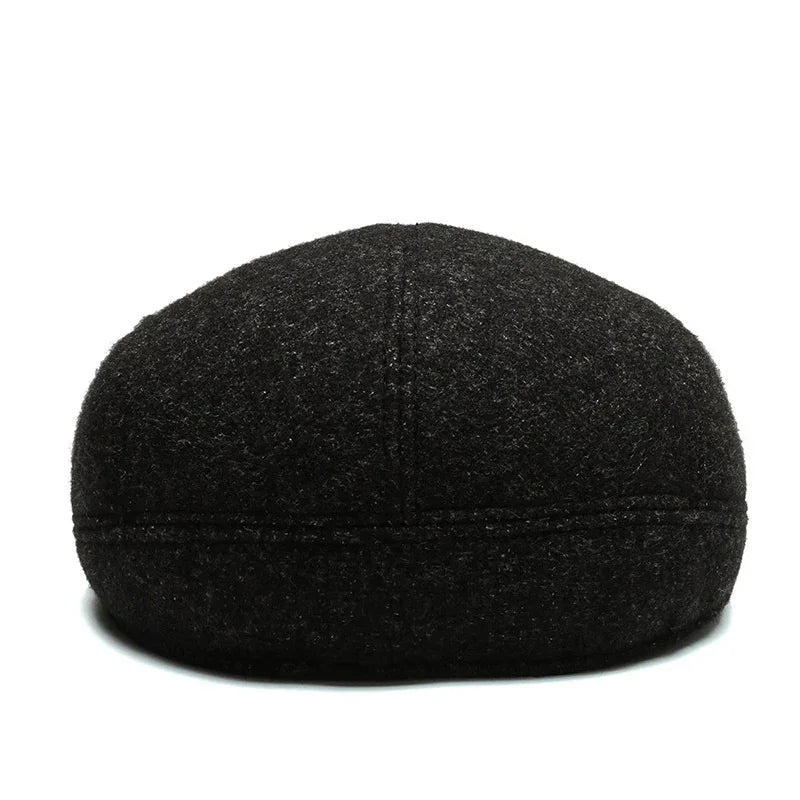 Black wool flat cap with visible stitching details on white background