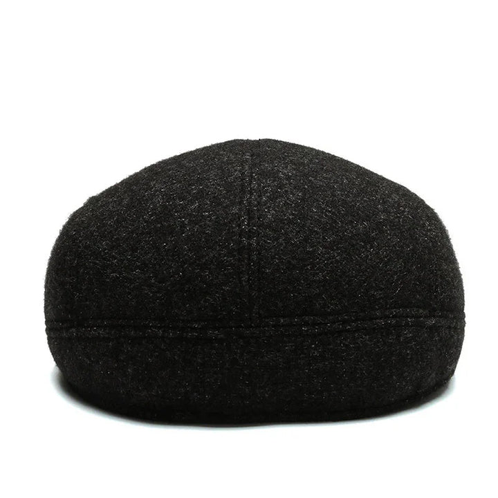 Black wool flat cap with visible stitching details on white background