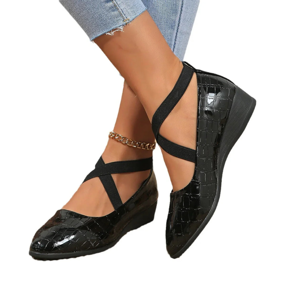 Womens black patent leather wedge shoes with crisscross elastic straps and gold ankle chain accessory