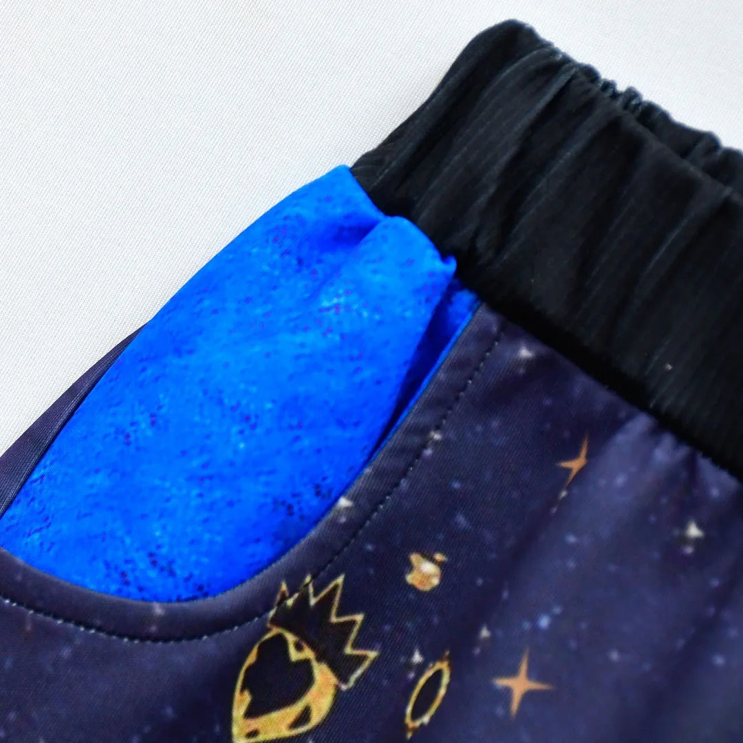 Close-up of blue and black fabric with celestial and crown pattern on clothing pocket