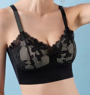 Close-up of a woman wearing a black lace bralette with floral patterns against a blue background