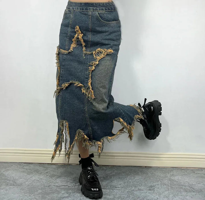 Distressed denim midi skirt with frayed star patch and hem worn with black chunky platform shoes