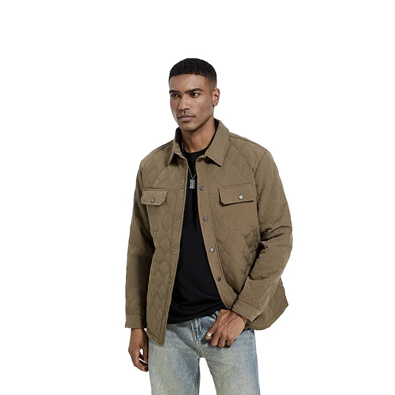 Man wearing brown quilted jacket with snap buttons over black shirt and light blue jeans