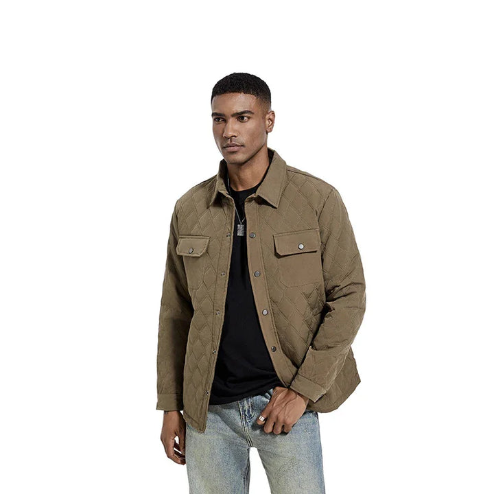 Man wearing brown quilted jacket with snap buttons over black shirt and light blue jeans