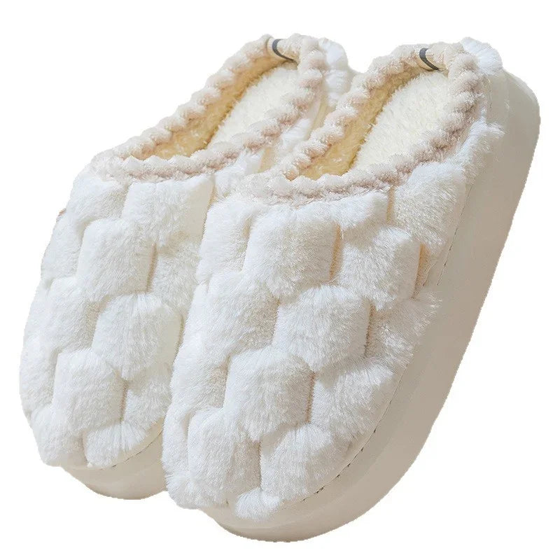 Pair of white plush house slippers with soft quilted design and fuzzy interior lining