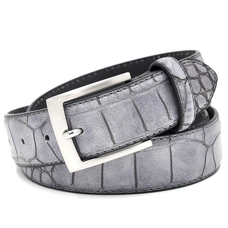Gray leather belt with crocodile texture and silver buckle rolled up on white background