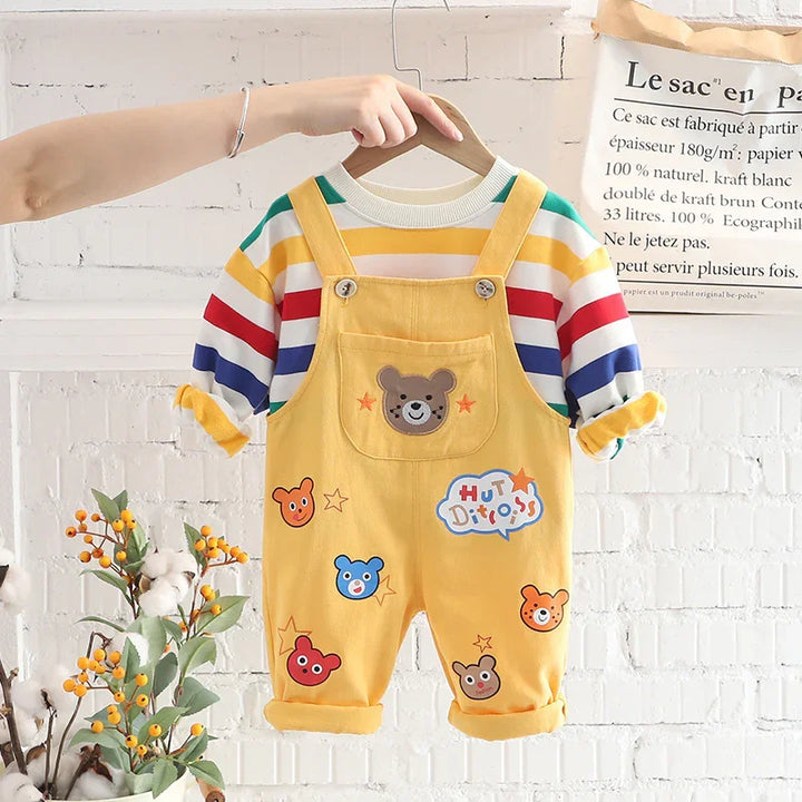 Yellow toddler overalls with bear patches and colorful striped long sleeve shirt on wooden hanger