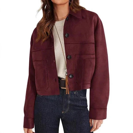 Woman wearing cropped maroon button-up jacket with pockets, white top, and dark jeans