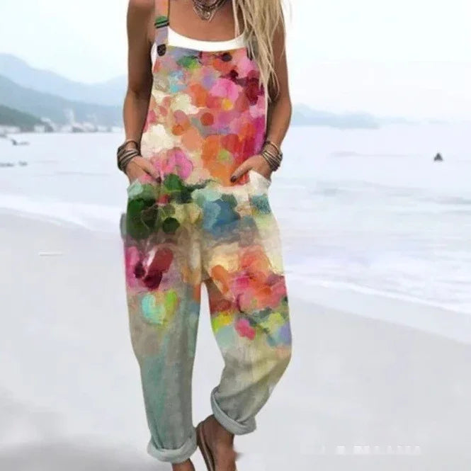 Woman wearing colorful floral print overalls with rolled cuffs standing on a beach