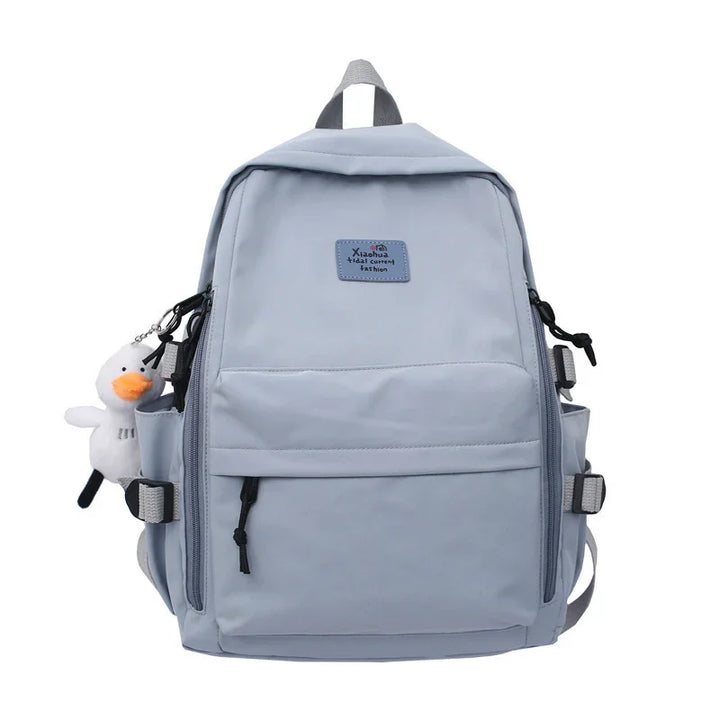 Light blue casual backpack with front zipper pocket and plush duck keychain accessory