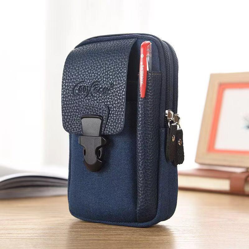 Compact navy blue canvas pouch with textured flap, front buckle closure, and pen holder on wooden desk