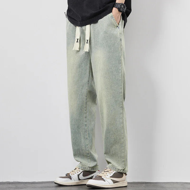 Casual light green faded sweatpants with white drawstrings worn with black and white sneakers