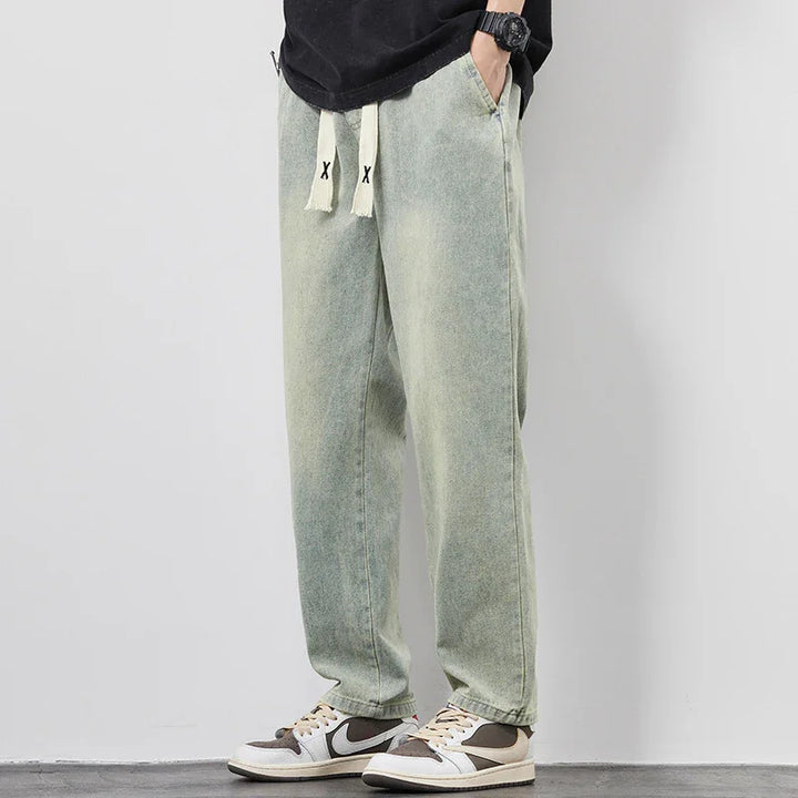Casual light green faded sweatpants with white drawstrings worn with black and white sneakers