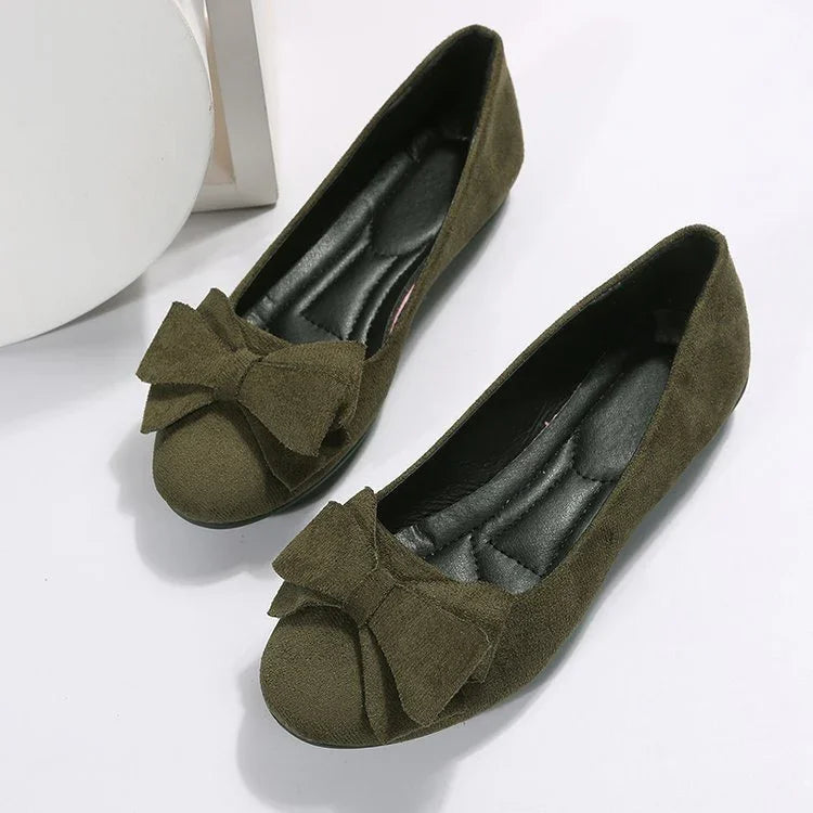 Olive green suede women’s ballet flats with large decorative bows and cushioned black insoles
