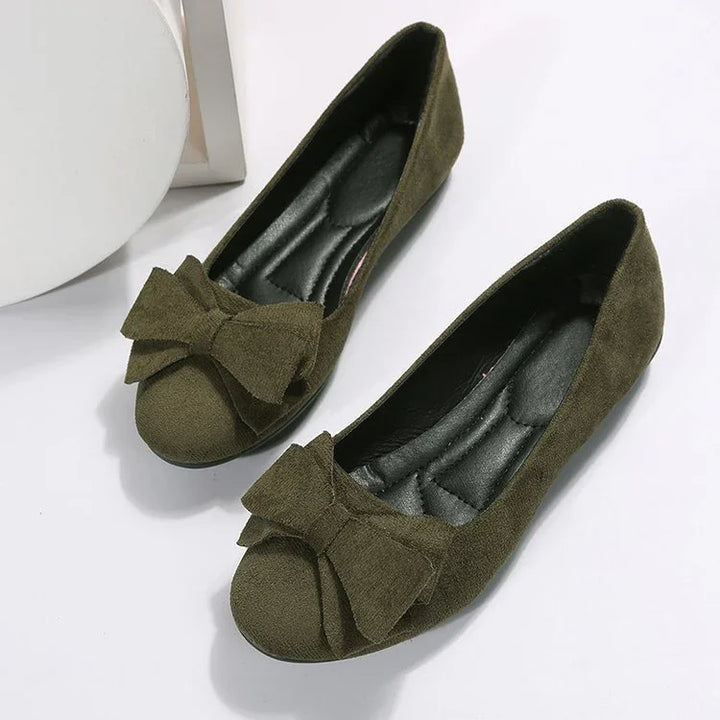 Olive green suede women’s ballet flats with large decorative bows and cushioned black insoles