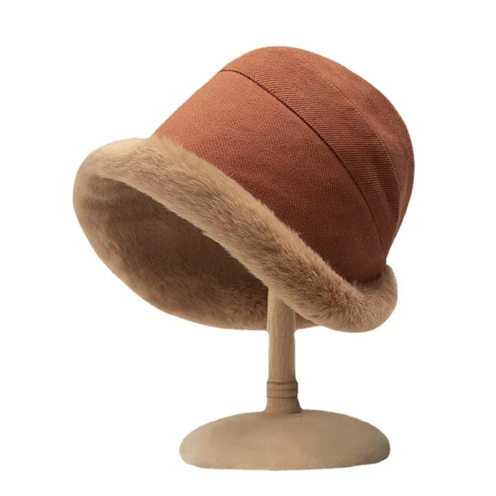 Brown winter hat with plush fur trim displayed on wooden hat stand