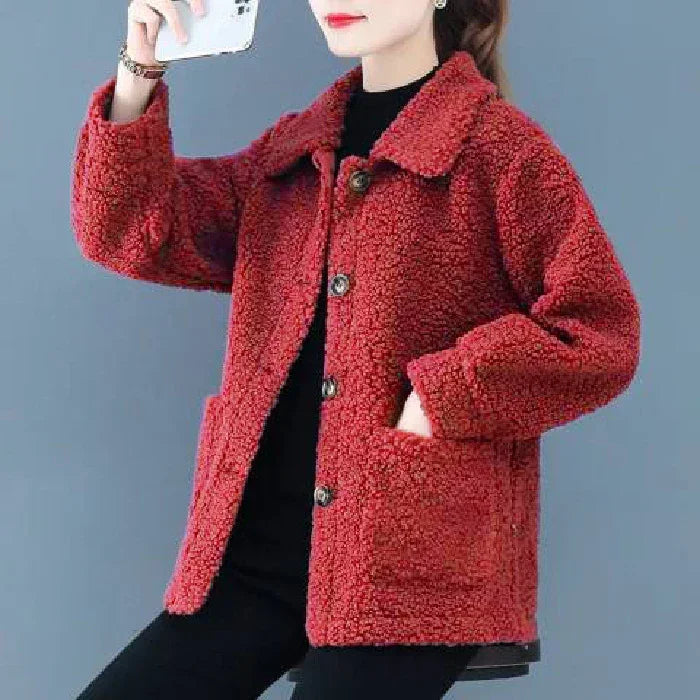 Woman wearing a red textured button-up fleece jacket with front pockets over black outfit