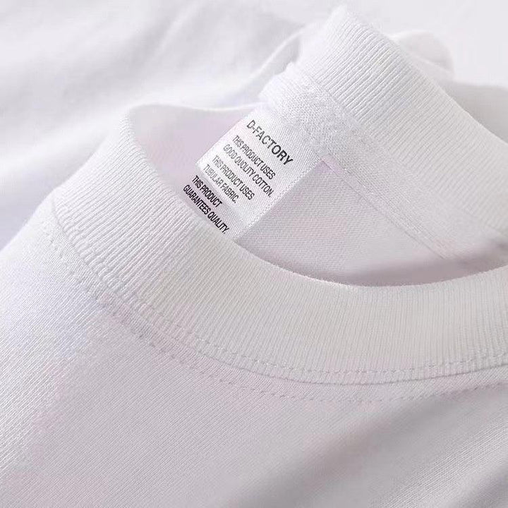 Close-up of white cotton t-shirt collar and tag showing D-Factory brand and fabric quality details