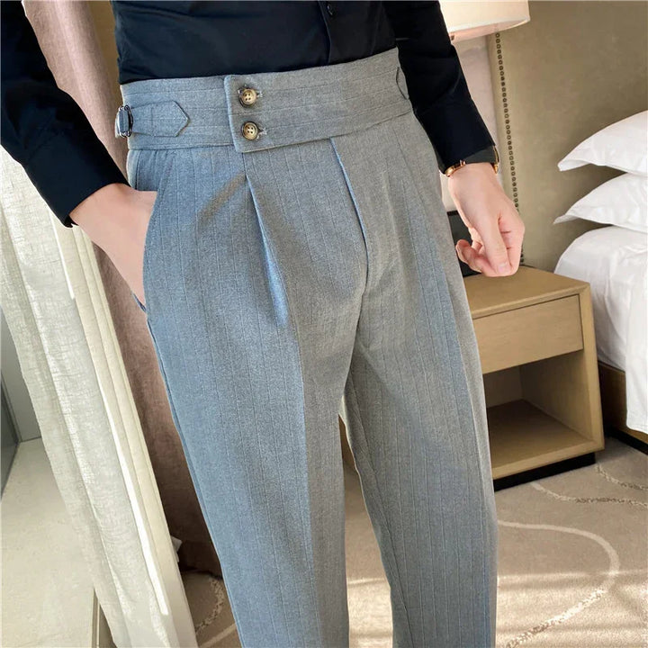 Close-up of grey pinstripe dress pants with unique buttoned waist detail and side pockets