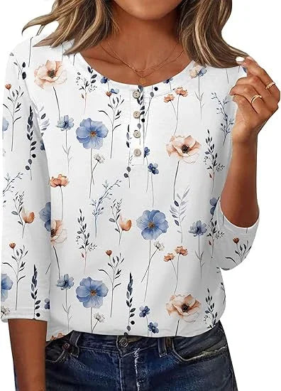 Woman wearing white floral blouse with blue and peach flowers and three-quarter sleeves