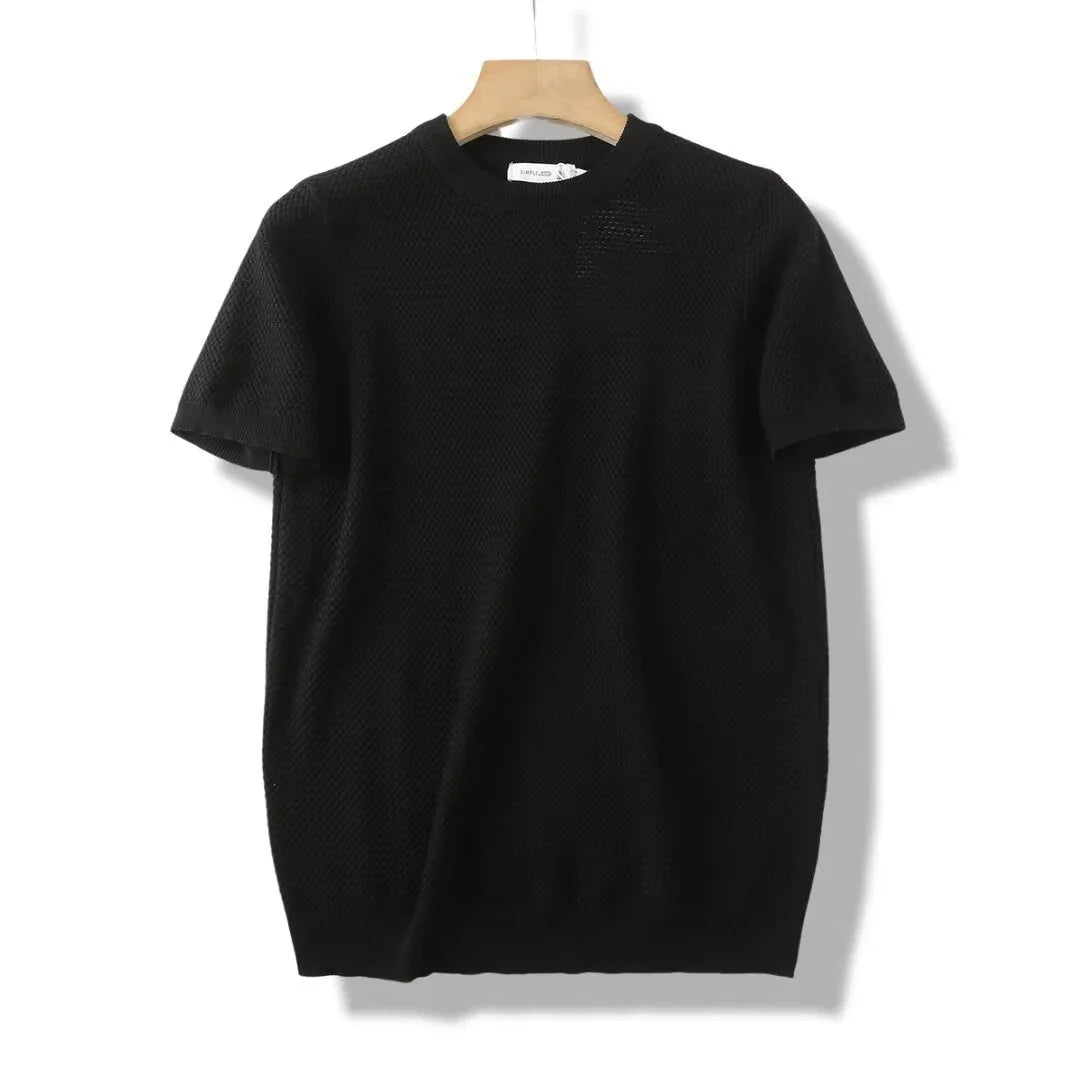 Black short-sleeve knit sweater on wooden hanger against white background