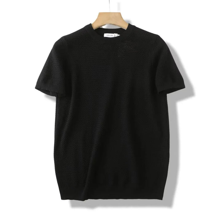 Black short-sleeve knit sweater on wooden hanger against white background