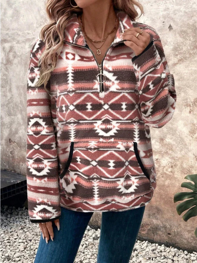 Woman wearing a brown and white patterned fleece pullover with quarter zipper and kangaroo pocket