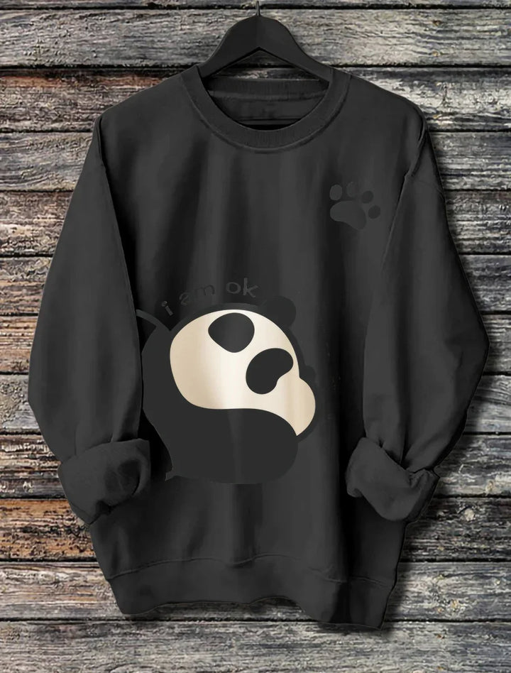 Black sweatshirt with a cute panda graphic and paw print detail hanging on a wooden background