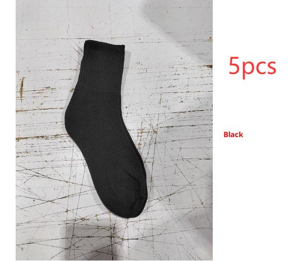 Single black ankle sock displayed on scratched white surface, labeled 5pcs Black