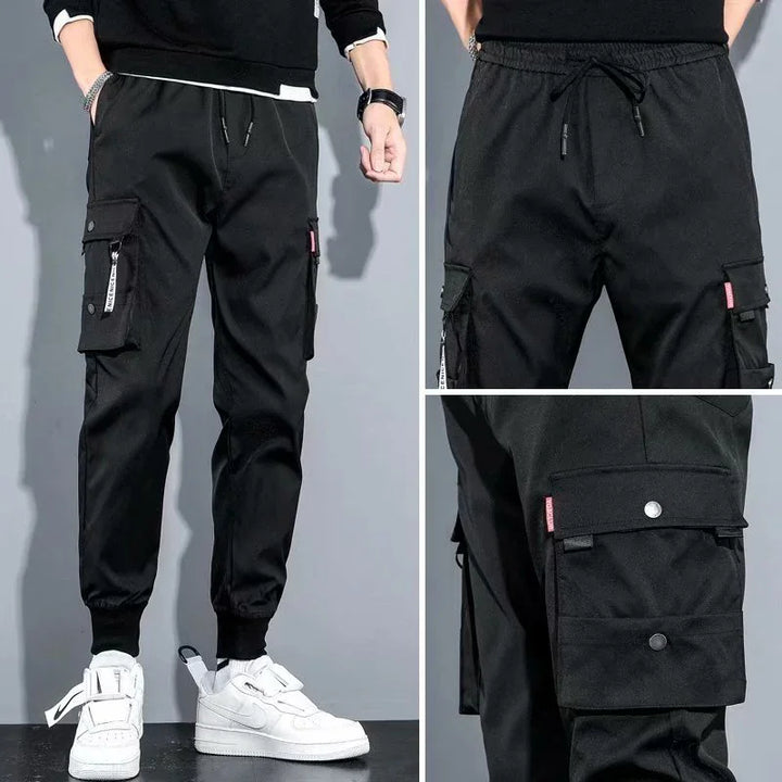 Black men's jogger cargo pants with elastic cuffs and multiple pockets paired with white sneakers