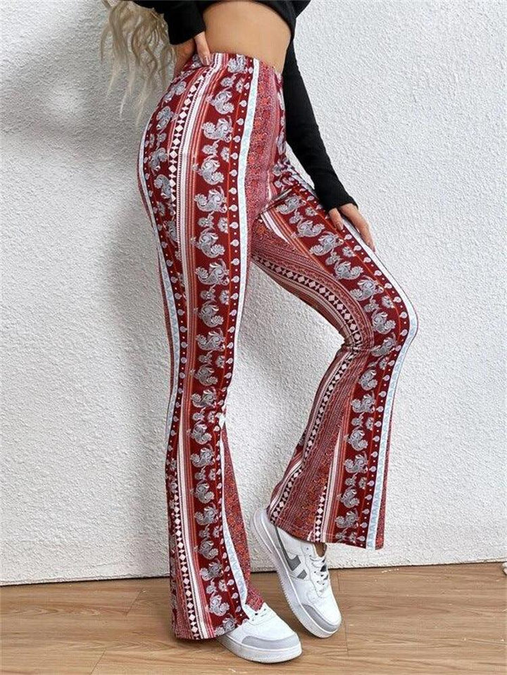 Woman wearing red patterned flared pants and white sneakers against white textured wall