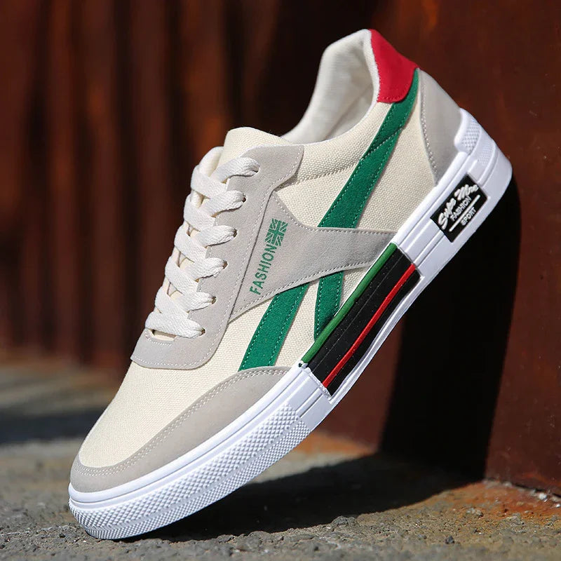 Beige canvas sneaker with green stripes, red heel accent, and white rubber sole on concrete