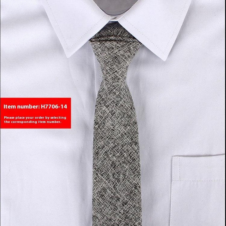 Close-up of gray textured necktie on white dress shirt with pointed collar and pocket