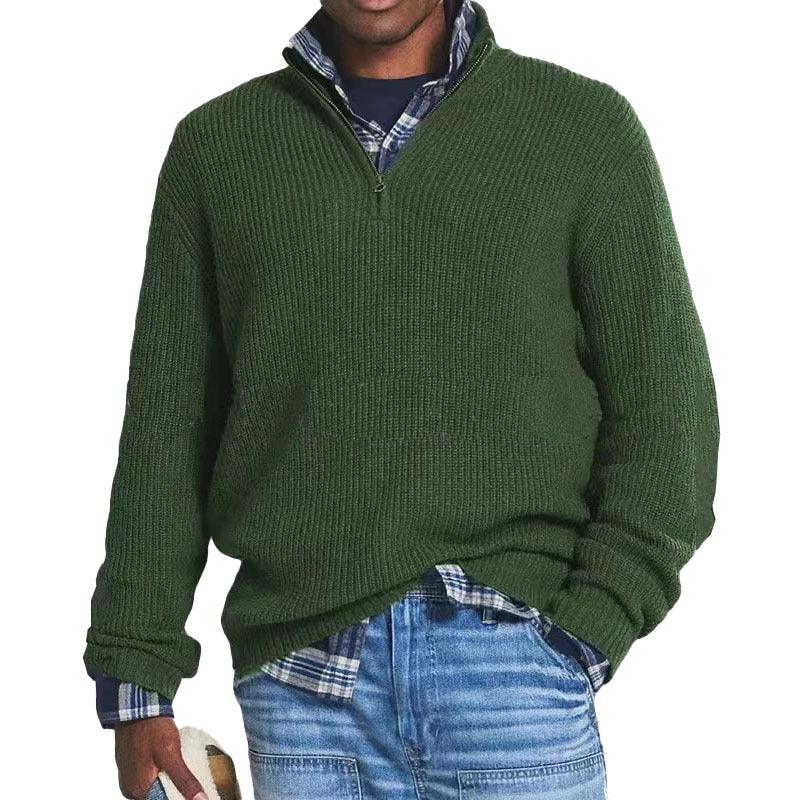 Man wearing textured dark green quarter-zip sweater over blue plaid shirt with light wash denim jeans