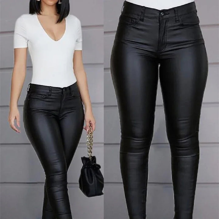 Woman wearing black leather skinny pants and white short-sleeve top holding black handbag with gold chain