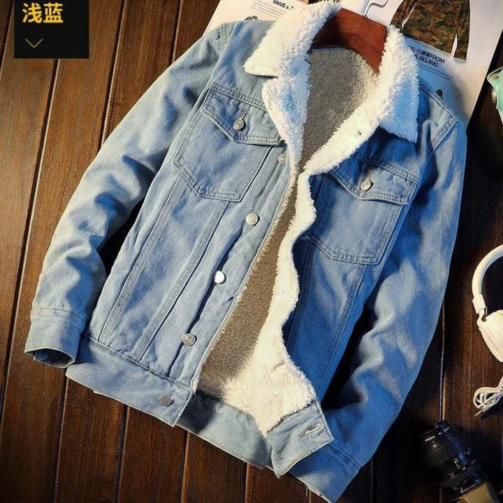 Light blue denim jacket with white sherpa lining and collar on wooden surface with headphones and camera