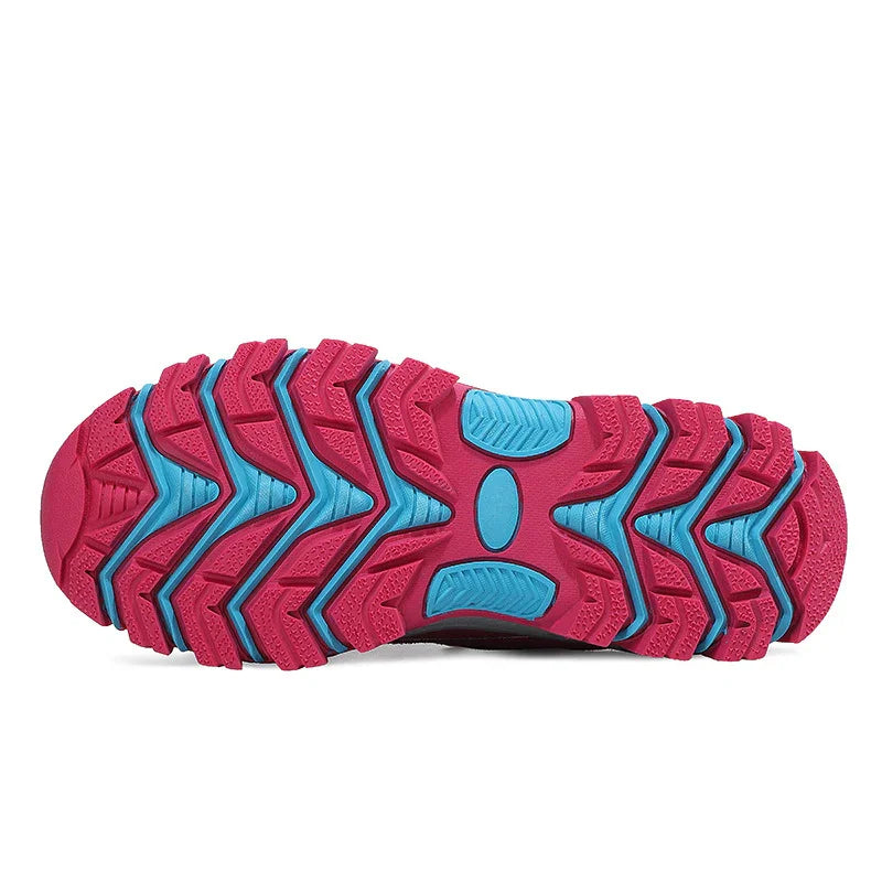 Close-up of a red and blue rugged shoe sole with thick, textured treads for outdoor traction