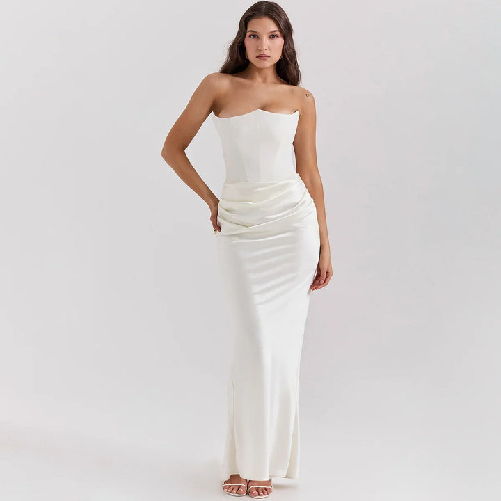 Woman in elegant strapless white satin evening gown with long skirt and ruched waist