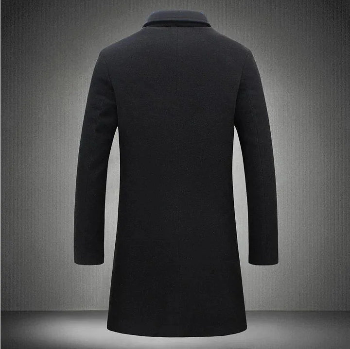 Back view of a black long wool coat with a classic collar on a textured gray background