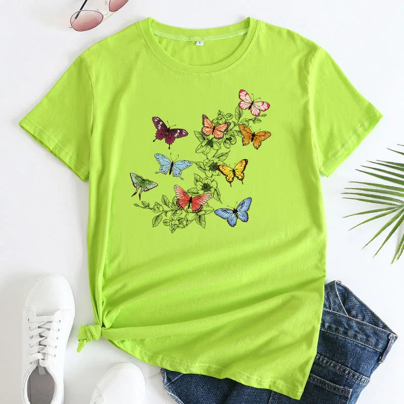 Lime green t-shirt with colorful butterfly and floral print, styled with denim shorts and white sneakers