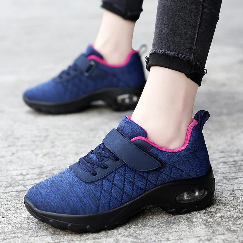 women's blue and pink walking shoes with thick sole and velcro strap on concrete surface