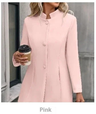 Woman wearing a pink long-sleeve buttoned coat holding a takeaway coffee cup outdoors