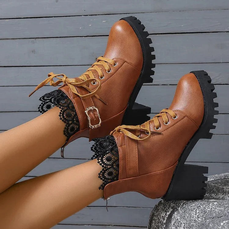 Brown leather lace-up ankle boots with black chunky heels and decorative buckles worn with black lace socks