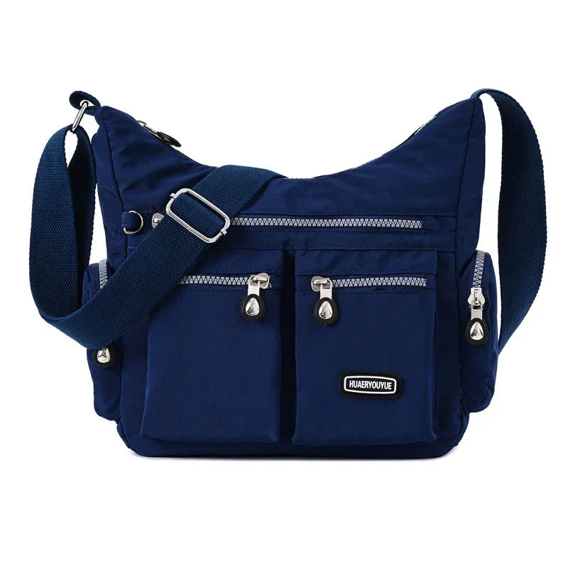 Navy blue crossbody bag with multiple zippered pockets and adjustable shoulder strap